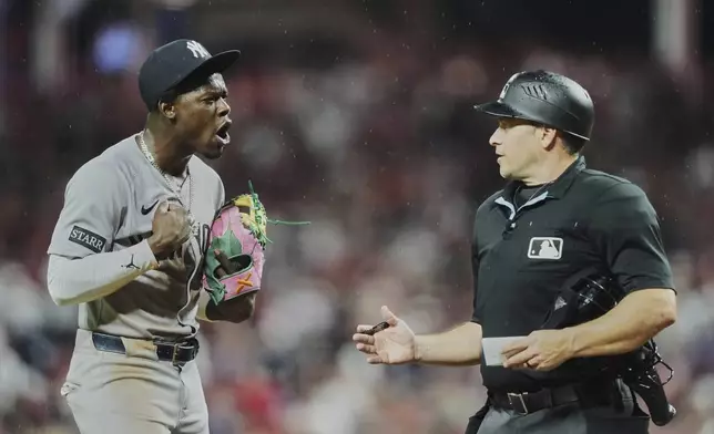 New York Yankees' Jazz Chisholm Jr., left, confronts home plate umpire Mark Wegner, right, while taking the field after being called out on strikes during the ninth inning of a baseball game against the Cincinnati Reds, Tuesday, June 24, 2025, in Cincinnati. (AP Photo/Joshua A. Bickel)