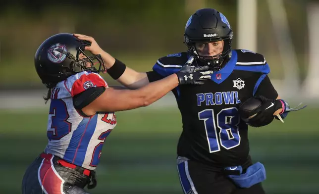 Detroit Prowl quarterback Allie Gorcyca, right, stiff arms Lansing Legacy's Ashley Graham during an AWFL women's football game in Allen Park, Mich., Saturday, May 10, 2025. (AP Photo/Paul Sancya)