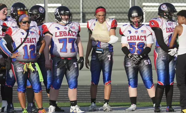 Lansing Legacy's Alexis Johnson stands on the sidelines with her arm wrapped after being injured in an AWFL women's football game against the Detroit Prowl, in Allen Park, Mich., Saturday, May 10, 2025. (AP Photo/Paul Sancya)