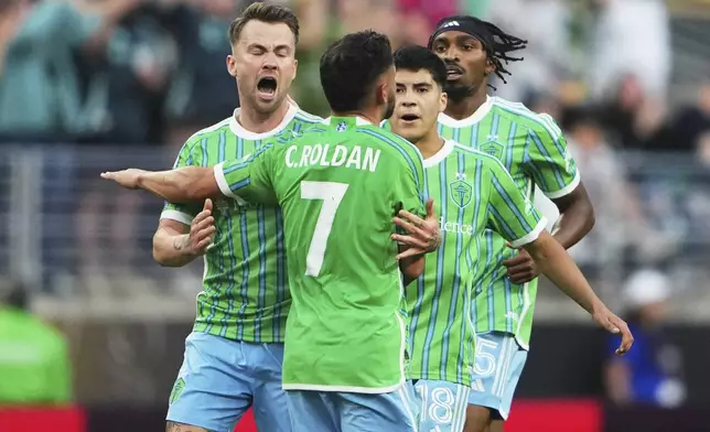 Seattle Sounders' Cristian Roldan is congratulated by teammates after scoring his team's first goal during the Club World Cup group B soccer match between Botafogo and Seattle Sounders at Seattle Lumen Field, in Seattle, Sunday, June 15, 2025. (AP Photo/Lindsey Wasson)