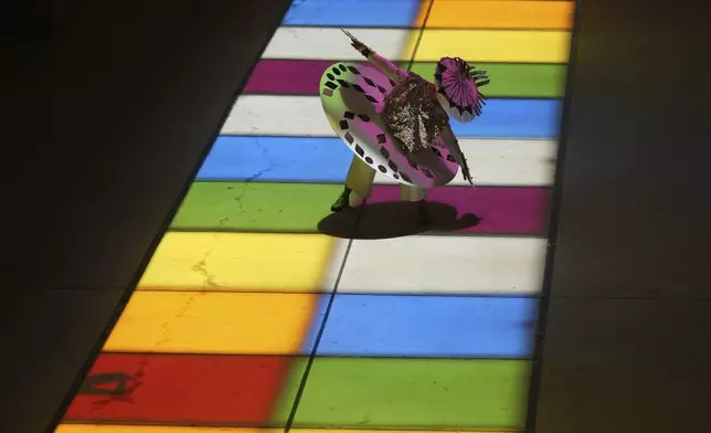 Catherine Cisneros performs a dance across the lighted squares of Christopher Janey's "Passing Light" solar sculpture that aligns each Summer Solstice at San Antonio International Airport, Friday, June 20, 2025, in San Antonio. (AP Photo/Eric Gay)