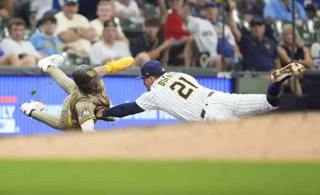 Milwaukee Brewers' Caleb Durbin (21) tags out San Diego Padres' Jackson Merrill at third base during the sixth inning of a baseball game Sunday, June 8, 2025, in Milwaukee. (AP Photo/Aaron Gash)