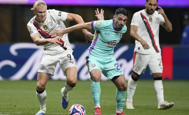 Manchester City's Erling Haaland, right, and Al Ain's Matias Palacios fight for the ball during the Club World Cup Group G soccer match between Manchester City and Al Ain in Atlanta, Sunday, June 22, 2025. (AP Photo/Brynn Anderson)