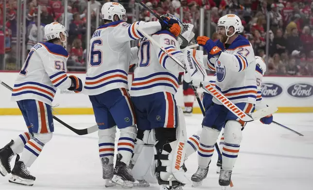 Edmonton Oilers players surround goaltender Calvin Pickard (30) after defeating the Florida Panthers in overtime during Game 4 of the NHL hockey Stanley Cup Final Thursday, June 12, 2025, in Sunrise, Fla. (AP Photo/Lynne Sladky)