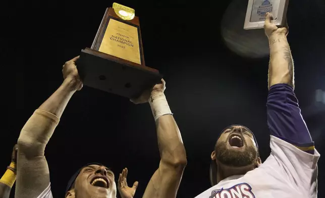 LSU Shreveport's Jose Sallorin, left, celebrates with the championship trophy after defeating Southeastern of Florida to win the championship game of the NAIA World Series colllege baseall game, Friday, May 30 2025, at Harris Field in Lewiston, Idaho. (Arthur H. Trickett-Wile/Lewiston Tribune via AP)
