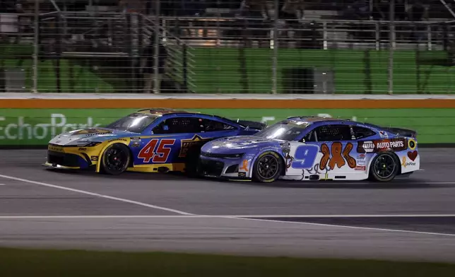 Tyler Reddick (45) races Chase Elliott (9) to the line to win Stage Two during a NASCAR Cup Series auto race, Saturday, June 28, 2025, in Hampton, Ga. (AP Photo/Butch Dill)