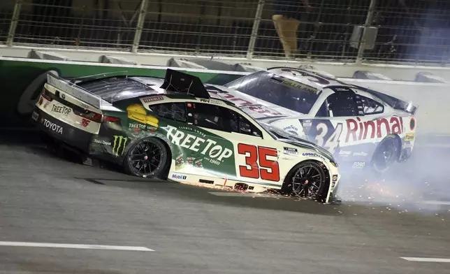 Driver Riley Herbst (35) and Todd Gilliland (34) collide in turn four during a NASCAR Cup Series auto race, Saturday, June 28, 2025, in Hampton, Ga. (AP Photo/Greg McWilliams)