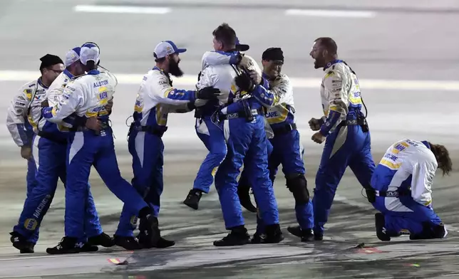 Crew members for driver Chase Elliott (9) celebrate after winning a NASCAR Cup Series auto race, Saturday, June 28, 2025, in Hampton, Ga. (AP Photo/Butch Dill)