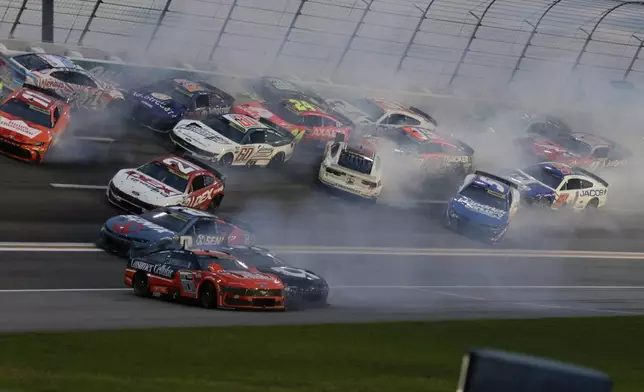 Twenty plus cars tangle up in turn three of lap sixty nine during a NASCAR Cup Series auto race, Saturday, June 28, 2025, in Hampton, Ga. (AP Photo/Russell Norris)