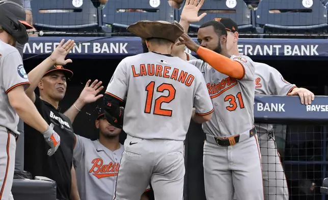 Baltimore Orioles' Ramón Laureano (12) and Cedric Mullins (31) celebrate Laureano's three-run home run during the second inning of a baseball game against the Tampa Bay Rays, Wednesday, June 18, 2025, in Tampa, Fla. (AP Photo/Jason Behnken)