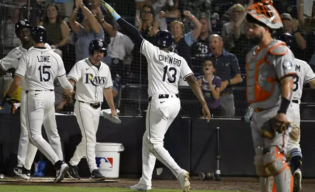 Tampa Bay Rays' Josh Lowe (15) and Junior Caminero (13) celebrate after scoring on a Jonathan Aranda single during the seventh inning of a baseball game against the Baltimore Orioles, Wednesday, June 18, 2025, in Tampa, Fla. (AP Photo/Jason Behnken)