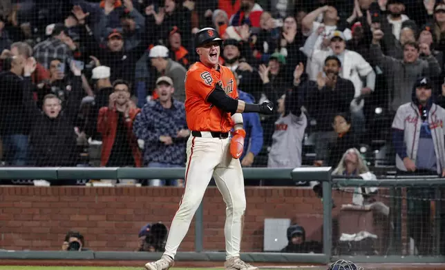 San Francisco Giants second baseman Tyler Fitzgerald (49) celebrates scoring from third base on a wild pitch by Atlanta Braves pitcher Pierce Johnson (38) in the 10th inning of a baseball game at Oracle Park in San Francisco, Friday, June 6, 2025. (Santiago Mejia/San Francisco Chronicle via AP)