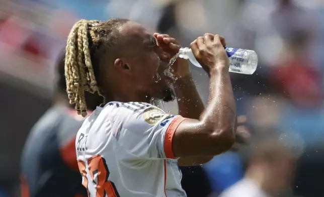 Bayern Munich's Sacha Boey poors water on his face during the Club World Cup Group C soccer match between Benfica and Bayern Munich in Charlotte, N.C., Tuesday, June 24, 2025. (AP Photo/Nell Redmond)