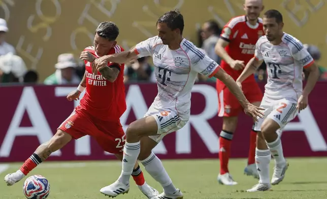 Benfica's Gianluca Prestianni, left, and Bayern Munich's Joao Palhinha fight for the ball during the Club World Cup Group C soccer match between Benfica and Bayern Munich in Charlotte, N.C., Tuesday, June 24, 2025. (AP Photo/Nell Redmond)