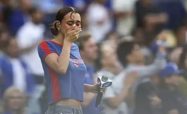 FILE - Music artist Nezza reacts after singing the national anthem prior to a baseball game between the Los Angeles Dodgers and the San Francisco Giants in Los Angeles, Saturday, June 14, 2025. (AP Photo/Jessie Alcheh, File)