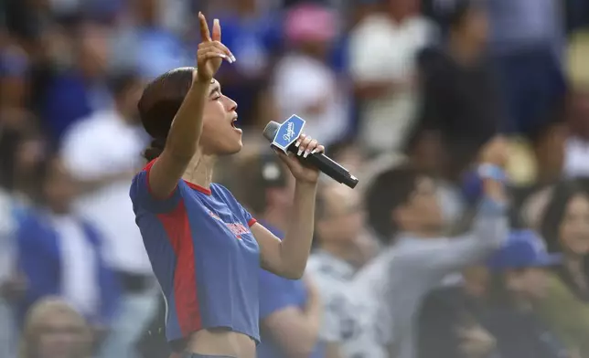 FILE - Music artist Nezza sings the national anthem prior to a baseball game between the Los Angeles Dodgers and the San Francisco Giants in Los Angeles, Saturday, June 14, 2025. (AP Photo/Jessie Alcheh, File)
