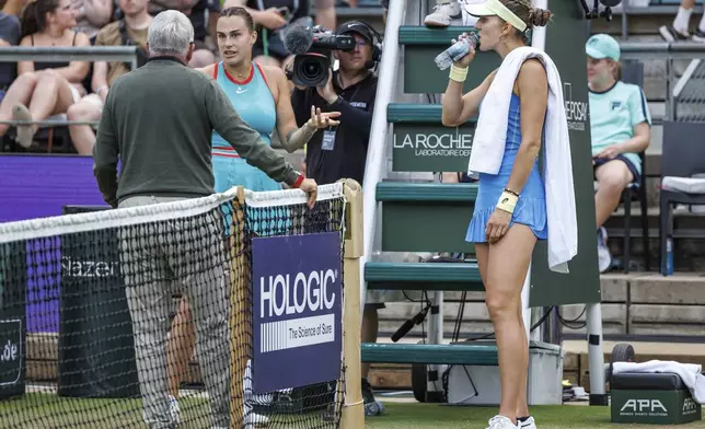Belarus's Aryna Sabalenka, left, and Switzerland's Rebeka Masarova talk to Official Referee Norbert Peick about the abandonment of the match during the round of 16 singles tennis match at the WTA tour in Berlin, Wednesday, June 18, 2025. (Andreas Gora/dpa via AP)