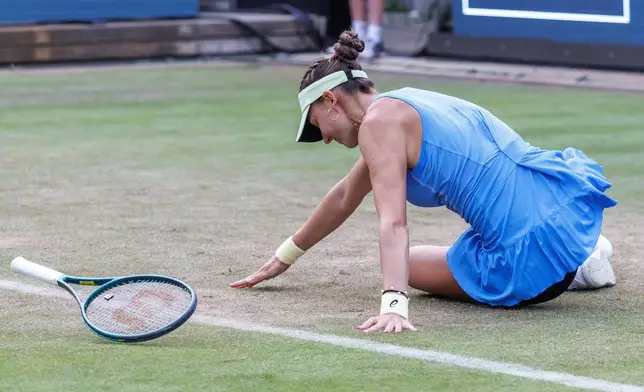 Switzerland's Rebeka Masarova slips on the grass as she plays Belarus' Aryna Sabalenka during their women's singles match of the Berlin WTA tennis tournament in Berlin, Germany, Wednesday, June 18, 2025. (Andreas Gora/dpa via AP)