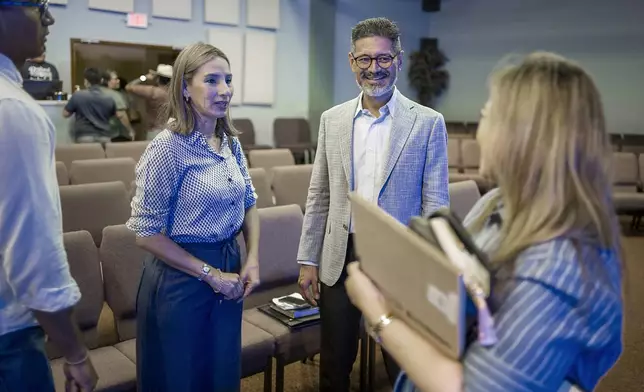 José Luis Orozco, a pastor from Nicaragua, speaks to Oasis Church, senior pastor, Maria Flores, right, following a sermon by Orozco, as son, Josias, and wife, Ruth, look on, in Taylor, Texas, June 15, 2025. (AP Photo/Rodolfo Gonzalez)