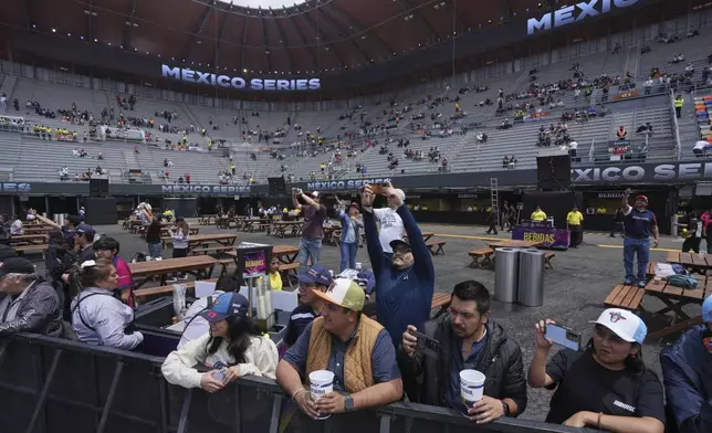 Fans take photos of NASCAR Mexico cars prior to a practice session for the NASCAR Cup Series auto race at Hermanos Rodriguez race track in Mexico City, Friday, June 13, 2025. (AP Photo/Fernando Llano)