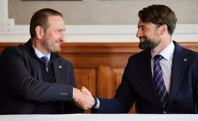 Rangers newly appointed manager Russell Martin, right, shakes hands with Sporting Director Kevin Thelwell during a press conference at Ibrox Stadium in Glasgow, Scotland Thursday, June 5, 2025. (Steve Welsh/PA via AP)