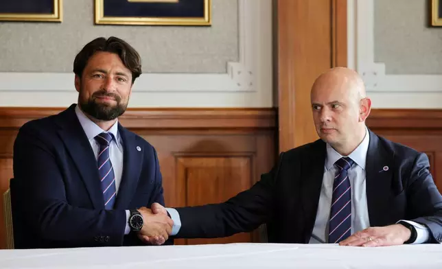 Rangers newly appointed manager Russell Martin, left, shakes hands with Chief Executive Officer Patrick Stewart during a press conference at Ibrox Stadium in Glasgow, Scotland Thursday, June 5, 2025. (Steve Welsh/PA via AP)