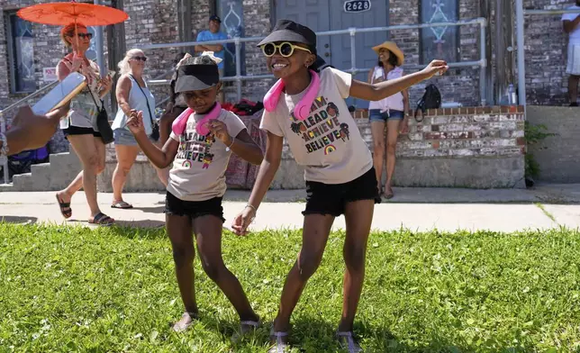 Kelsea and Kennedy Branford watch during a Juneteenth parade Thursday, June 19, 2025, in Galveston, Texas. (AP Photo/David J. Phillip)