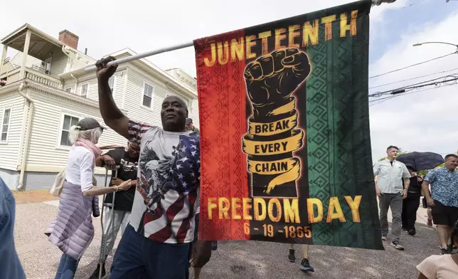 Robert Reid holds a flag during a Juneteenth celebration at the African Burying Ground Memorial Park Thursday, June 19, 2025, in Portsmouth, N.H. (AP Photo/Michael Dwyer)