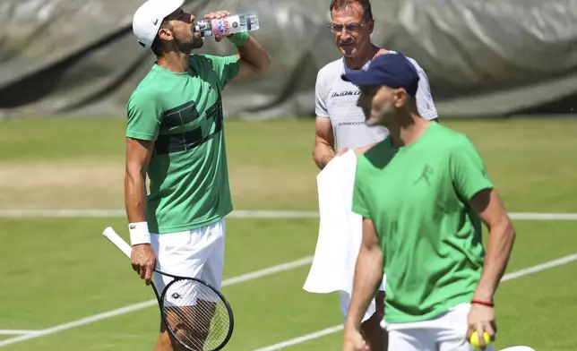 Novak Djokovic of Serbia with members of his team during a practice session ahead of the Wimbledon Championships at the All England Lawn Tennis and Croquet Club in London, Sunday, June 29, 2025. (AP Photo/Kirsty Wigglesworth)