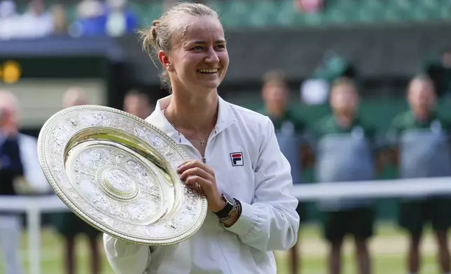 FILE - Barbora Krejcikova of the Czech Republic holds her trophy after defeating Jasmine Paolini of Italy in the women's singles final at the Wimbledon tennis championships in London, Saturday, July 13, 2024. (AP Photo/Kirsty Wigglesworth,File)