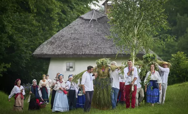 People perform a rite during a traditional midsummer celebration in Pyrohiv, Ukraine, outside of Kyiv, Saturday, June 21, 2025. (AP Photo/Efrem Lukatsky)