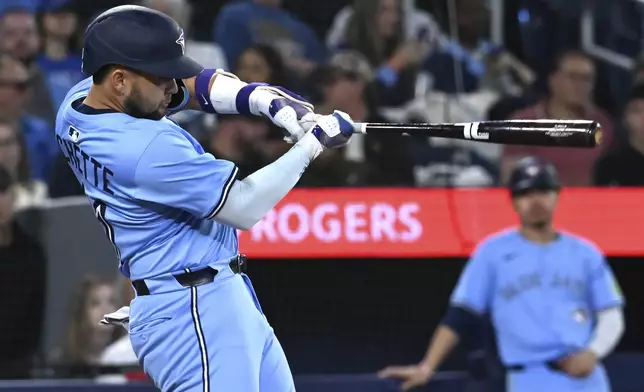 Toronto Blue Jays' Bo Bichette (11) hits a solo hime run against the Athletics during ssecond inning of a baseball game in Toronto, Saturday, May 31, 2025. (Jon Blacker/The Canadian Press via AP)