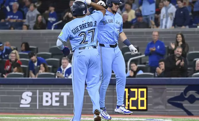 Toronto Blue Jays' Addison Barger, right, celebrates with Vladimir Guerrero Jr (27) after hitting a two-run home run against the Athletics in the first inning of a baseball game in Toronto, Saturday, May 31, 2025. (Jon Blacker/The Canadian Press via AP)
