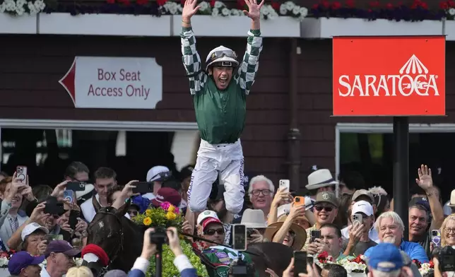 Jockey Lanfranco Dettori jumps off Raging Torrent after winning the 132nd running of the Metropolitan Handicap horse race, Saturday, June 7, 2025, in Saratoga Springs, N.Y. (AP Photo/Seth Wenig)