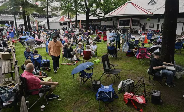 Horse racing fans lounge on the grounds of Saratoga Race Course before the 157th running of the Belmont Stakes horse race, Saturday, June 7, 2025, in Saratoga Springs, N.Y. (AP Photo/Jessica Hill)