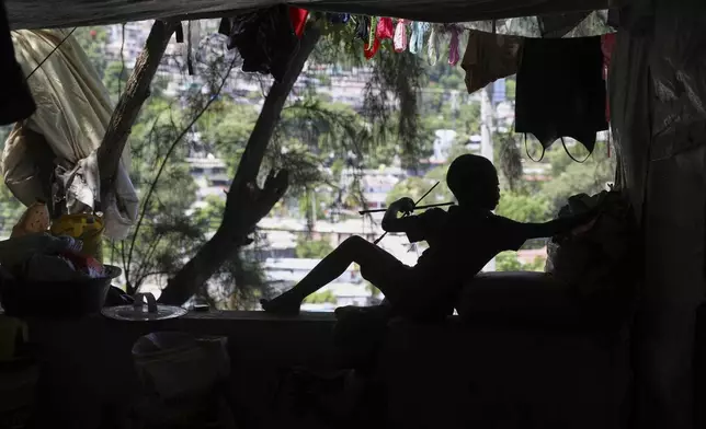 A child builds a kite at a shelter for families displaced by gang violence in Port-au-Prince, Haiti, Thursday, June 5, 2025.(AP Photo/Odelyn Joseph)