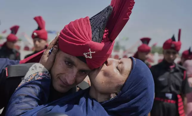 A Kashmiri woman kisses her son, a newly recruited soldier of Indian army during the graduation parade ceremony on the outskirts of Srinagar, Indian controlled Kashmir, Thursday, June 5, 2025. (AP Photo/Mukhtar Khan)