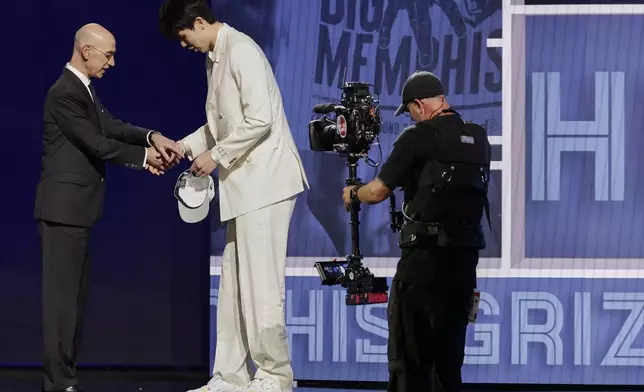Hansen Yang greets NBA commissioner Adam Silver after being selected 16th by the Memphis Grizzlies in the first round of the NBA basketball draft, Wednesday, June 25, 2025, in New York. (AP Photo/Adam Hunger)