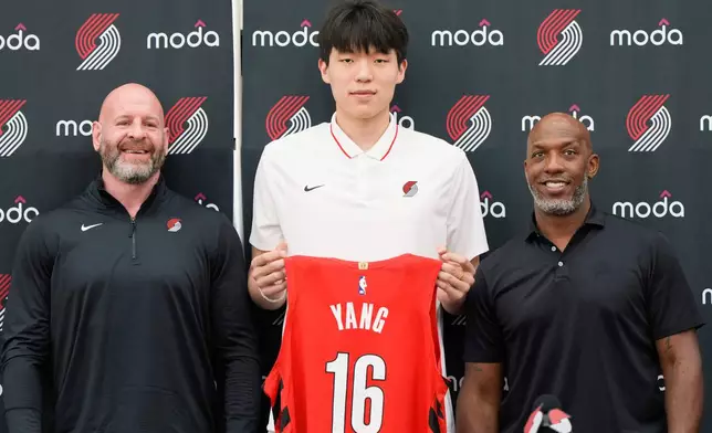 Portland Trail Blazers' Yang Hansen, of China, center, poses for a photo with general manager Joe Cronin, left, and head coach Chauncey Billups during an NBA basketball press conference, Friday, June 27, 2025, in Portland, Ore. (AP Photo/Jenny Kane)