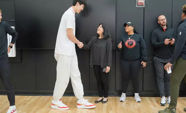 Portland Trail Blazers center Yang Hansen, of China, greets people after speaking during an NBA basketball press conference, Friday, June 27, 2025, in Portland, Ore. (AP Photo/Jenny Kane)