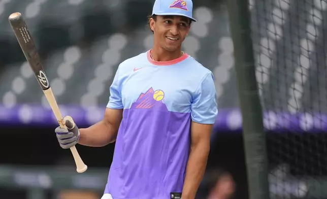 Colorado Rockies shortstop Ryan Ritter warms up before making his Major League debut in baseball game against the New York Mets, Friday, June 6, 2025, in Denver. (AP Photo/David Zalubowski)