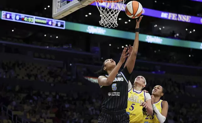 Chicago Sky forward Angel Reese, left, shoots against Los Angeles Sparks forward Dearica Hamby, center, as Sparks forward Azura Stevens, right, watches during the first half of a WNBA basketball game, Sunday, June 29, 2025, in Los Angeles. (AP Photo/Jessie Alcheh)