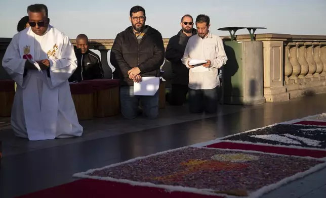 People pray before the start of a Mass celebrating the Catholic holiday of Corpus Christi a tthe Christ the Redeemer statue in Rio de Janeiro, Thursday, June 19, 2025 (AP Photo/Bruna Prado)