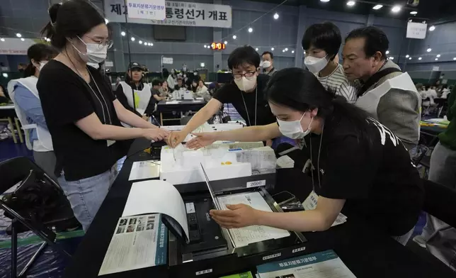 National Election Commission officials work to sort out ballots for counting at the presidential election in Seoul, South Korea, Tuesday, June 3, 2025. (AP Photo/Ahn Young-joon)
