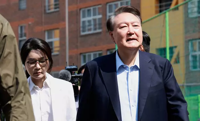Former South Korean President Yoon Suk Yeol, right, and former first lady Kim Keon-Hee arrive to cast their votes for the presidential election at a polling station in Seoul, South Korea, Tuesday, June 3, 2025. (Shin Hyun-woo/Yonhap via AP)