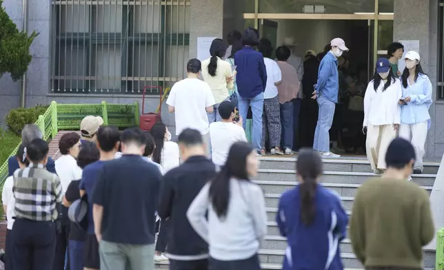 People wait in line to cast their votes for the presidential election at a polling station in Seoul, South Korea, Tuesday, June 3, 2025. (AP Photo/Lee Jin-man)