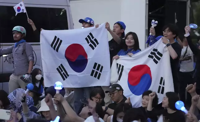 Supporters of South Korea Democratic Party's presidential candidate Lee Jae-myung react as they watch monitors broadcasting the results of exit polls for a presidential election outside of the National Assembly in Seoul, South Korea, Tuesday, June 3, 2025. (AP Photo/Lee Jin-man)