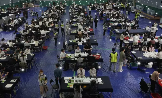 National Election Commission officials sort out ballots for counting at the presidential election in Seoul, South Korea, Tuesday, June 3, 2025. (AP Photo/Ahn Young-joon)