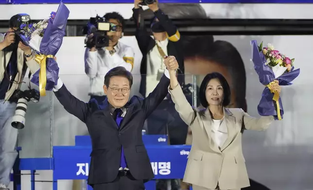 South Korea's Democratic Party's presidential candidate Lee Jae-myung, and his wife Kim Hea Kyung, celebrate outside of the National Assembly in Seoul, South Korea, Wednesday, June 4, 2025. (AP Photo/Lee Jin-man)