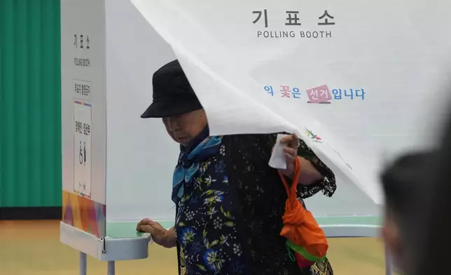 A woman exits a polling booth to cast her ballot for the presidential election at a polling station in Seoul, South Korea, Tuesday, June 3, 2025. (AP Photo/Lee Jin-man)
